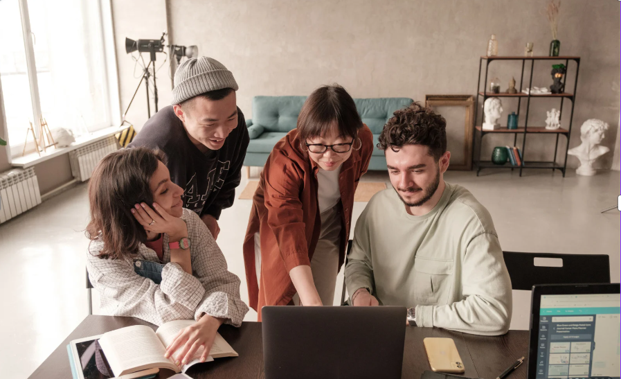 Emprendedores trabajando juntos en un ordenador mientras planifican los pasos para registrar y gestionar una empresa en UK.